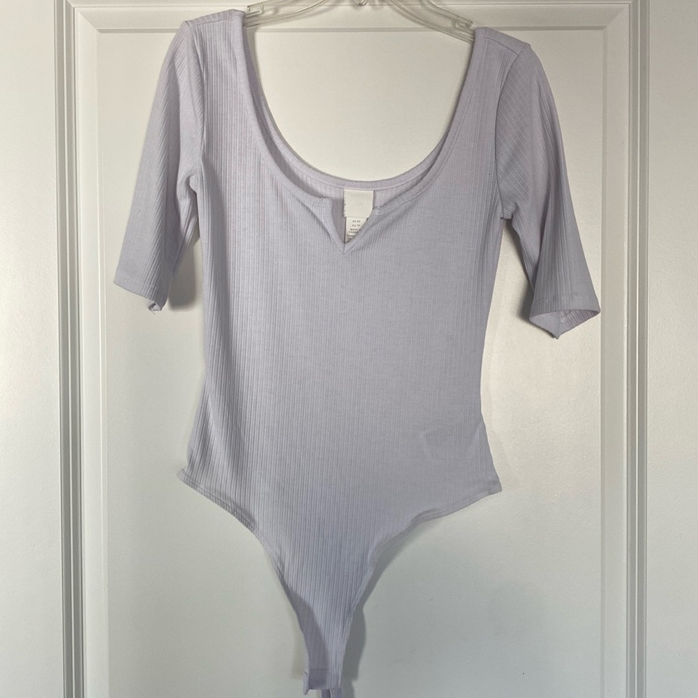 White, short sleeved body suit with V dip in middle